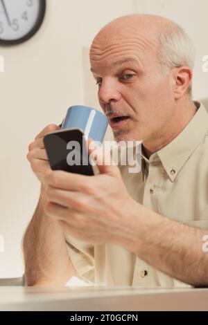 Älterer Mann schätzt moderne Technik, verwendet Geräte in Pausen. Vergangene Generationen schätzen Fortschritte, ohne sie als selbstverständlich zu betrachten. Navigieren im W Stockfoto