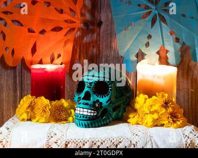 Komposition des traditionellen Altars für den mexikanischen Totentag mit Schädel, Kerzen, Opfergaben und Blumen. Stockfoto