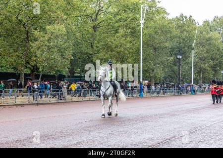 London, eine Polizistin, die auf einem weißen Pferd entlang der Mall reitet, führt die Kings Changing of the Guard, London, England, September 2023 Stockfoto