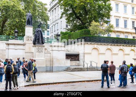 London The Mall, Tour-Gruppen sehen Statuen von Queen Elizabeth der Königin Mutter und König George V1 in der Mall in London, England, Großbritannien Stockfoto