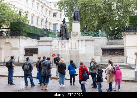 London The Mall, Tour-Gruppen sehen Statuen von Queen Elizabeth der Königin Mutter und König George V1 in der Mall in London, England, Großbritannien Stockfoto