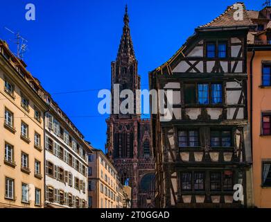 Fassade und Turm der Kathedrale Notre Dame und kunstvolle traditionelle Fachwerkhäuser mit steilen Dächern umgeben sie in Straßburg, Elsass, Frankreich Stockfoto