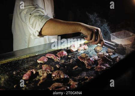 Im Outback, einem Koch, der Barbecue-Känguru kocht, können Sie nicht mehr australischer essen als dieses, wenn Sie im Uluru unter dem Sternenhimmel speisen. Stockfoto