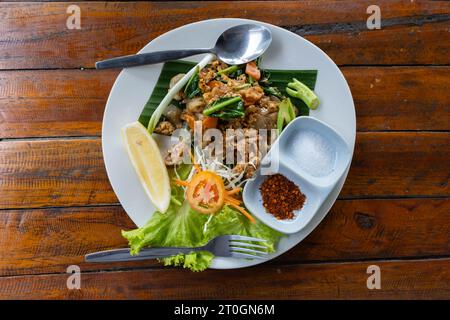 Gebratene Reisnudeln mit schwarzer Sojasauce, Schweinefleisch und Grünkohl. Thailändische Küche (Pad siehe Ew) Stockfoto