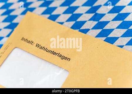 Augsburg, Bayern, Deutschland. September 2023. Umschlag mit Wahlunterlagen zur Landtagswahl in Bayern auf bayerischer Flagge *** Umschlag mit Wahlunterlagen zur Landtagswahl in Bayern auf einer bayerischen Flagge Credit: Imago/Alamy Live News Stockfoto
