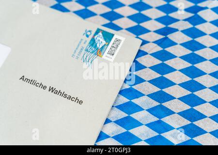 Augsburg, Bayern, Deutschland. September 2023. Umschlag mit Wahlunterlagen zur Landtagswahl in Bayern auf bayerischer Flagge *** Umschlag mit Wahlunterlagen zur Landtagswahl in Bayern auf einer bayerischen Flagge Credit: Imago/Alamy Live News Stockfoto