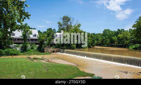 Helena, Alabama, USA-15. Juli 2023: Malerischer Blick auf die Altstadt im historischen Helena mit Buck Creek und dem alten Mühlendamm an einem klaren blauen Sommertag. Stockfoto