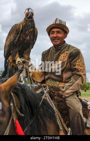 Bokonbayevo, Kirgisistan – 22. September 2023: Adlerjäger und sein Goldener Adler in Bokonbayevo, Issyk Kul Lake, Kirgisistan. Stockfoto