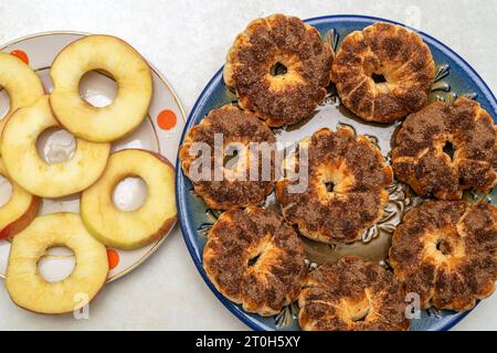 Apfelringe sind roh und in Zimtteig gebacken. Draufsicht. Stockfoto