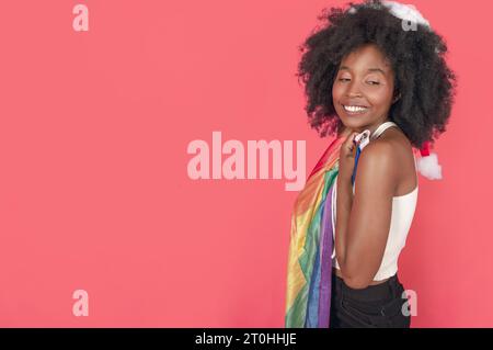 Glückliche, stolze Frau mit einer bunten Flagge, waagerecht rosa Hintergrund Stockfoto