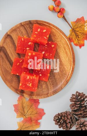 Bombay Halwa ist ein beliebtes indisches Dessert, das auf einem Teller serviert und dekoriert wird. Bombay Halwa Wüste in einem isolierten Hintergrund. Indisches Festival süßes Gericht. Stockfoto