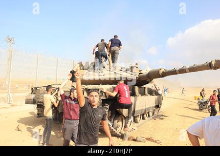 Rafah, Gaza. Oktober 2023. Die Palästinenser übernehmen die Kontrolle über einen israelischen Panzer, nachdem sie am Samstag, 7. Oktober 2023, den Grenzzaun mit Israel von Khan Yunis im südlichen Gazastreifen überquert haben. Während Militante der blockierten palästinensischen Enklave Israel infiltrierten, wurden in der Morgenröte Raketenfluten aus dem Gazastreifen auf Israel abgefeuert. Foto: Ismael Mohamad/UPI. Quelle: UPI/Alamy Live News Stockfoto