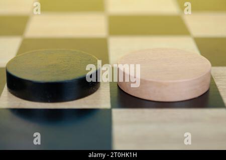 Schwarze und braune Rundhölzer auf leerem Schachbrett. Stockfoto