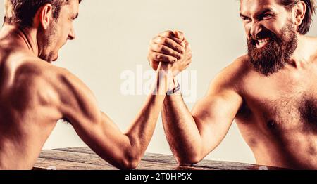 Arme ringen dünne Hand, großer starker Arm im Studio. Zwei Männerhände umklammten Arm Wrestling, stark und schwach, ungleiche Übereinstimmung Stockfoto