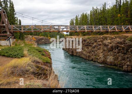 Ein Blick auf die Robert Lowe Hängebrücke über den Yukon River, die durch den Miles Canyon in Yukon, Kanada führt. Stockfoto