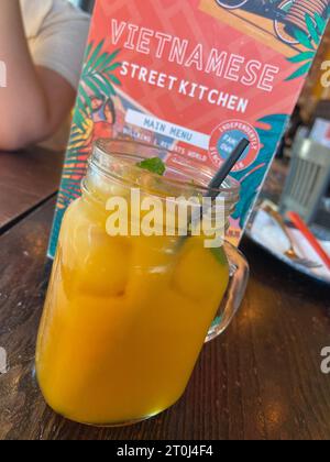 Frischer Mangosaft, serviert in einem Glas in der Vietnamese Street Kitchen, ein erfrischendes tropisches Getränk. Stockfoto