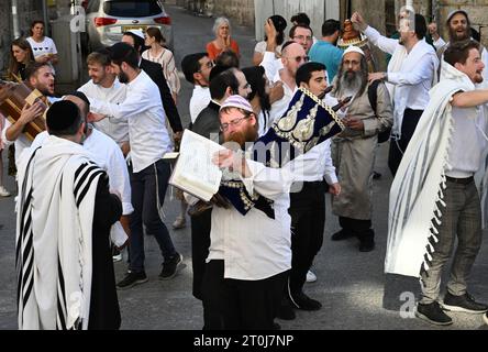 Erusalem, Israel. Oktober 2023. Orthodoxe Juden tanzen mit Tora-Schriftrollen am jüdischen Feiertag der Simchat-Tora in Jerusalem am Samstag, 7. Oktober 2023. Die israelischen Behörden sagen, dass mehr als 100 Menschen von den palästinensischen Militanten Hamas getötet und Dutzende gefangen genommen wurden, nachdem sie am frühen Morgen überraschend aus Gaza auf israelisches Gebiet eingedrungen waren. Foto: Debbie Hill/ Credit: UPI/Alamy Live News Stockfoto