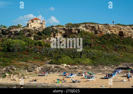 Touristen genießen die Sonne am Strand von Agios Georgios Paphos, Zypern Stockfoto