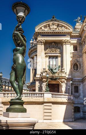 Ein fesselnder Blick auf das Pariser Opernhaus mit seiner königlichen Statue im Vordergrund. Stockfoto