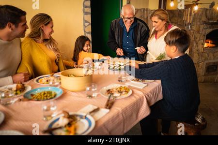 Fröhliche lateinamerikanische Familie, die Spaß bei der Zubereitung des gemeinsamen Abendessens zu Hause hat - hispanische Menschen und Lebensstil-Konzept Stockfoto