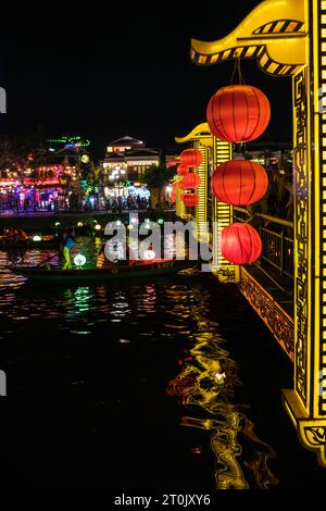 Hoi An, Vietnam. Fußgängerbrücke und Touristenboote auf dem Fluss Thu Bon bei Nacht. Stockfoto