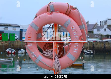 Ein Foto von einem blassorangen Rettungsring neben einem Hafen. Stockfoto