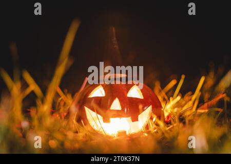 Augsburg, Bayern, Deutschland. Oktober 2023. Glühender Halloween Kürbis mit Hexenhut in der Nacht. Gruseliger Kürbis *** Leuchtender Halloween Kürbis mit Hexenhut bei Nacht. Gruseliger Kürbis Credit: Imago/Alamy Live News Stockfoto