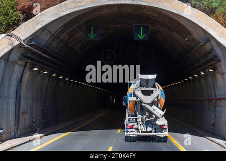 Betonmischwagen, der in einen Straßentunnel einfährt. Stockfoto