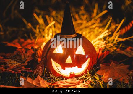 Augsburg, Bayern, Deutschland. Oktober 2023. Glühender Halloween Kürbis mit Hexenhut in der Nacht. Gruseliger Kürbis *** Leuchtender Halloween Kürbis mit Hexenhut bei Nacht. Gruseliger Kürbis Credit: Imago/Alamy Live News Stockfoto