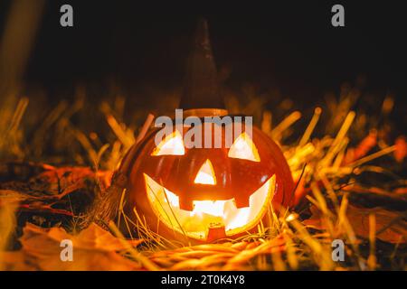 Augsburg, Bayern, Deutschland. Oktober 2023. Glühender Halloween Kürbis mit Hexenhut in der Nacht. Gruseliger Kürbis *** Leuchtender Halloween Kürbis mit Hexenhut bei Nacht. Gruseliger Kürbis Credit: Imago/Alamy Live News Stockfoto