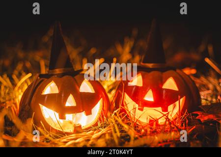 Augsburg, Bayern, Deutschland. Oktober 2023. Glühende Halloween-Kürbisse mit Hexenhut in der Nacht. Gruseliger Kürbis *** Leuchtende Halloween Kürbise mit Hexenhut bei Nacht. Gruseliger Kürbis Credit: Imago/Alamy Live News Stockfoto