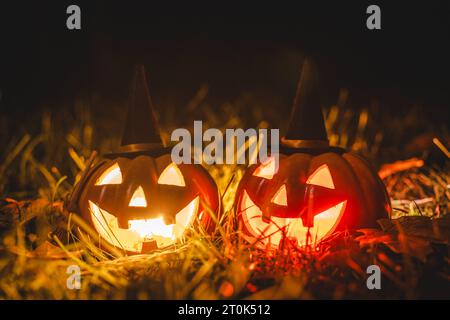 Augsburg, Bayern, Deutschland. Oktober 2023. Glühende Halloween-Kürbisse mit Hexenhut in der Nacht. Gruseliger Kürbis *** Leuchtende Halloween Kürbise mit Hexenhut bei Nacht. Gruseliger Kürbis Credit: Imago/Alamy Live News Stockfoto