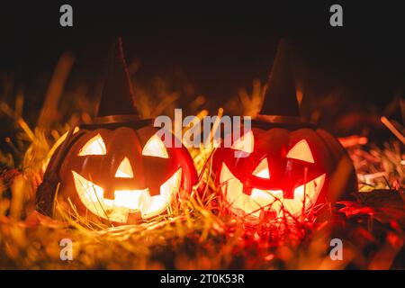 Augsburg, Bayern, Deutschland. Oktober 2023. Glühende Halloween-Kürbisse mit Hexenhut in der Nacht. Gruseliger Kürbis *** Leuchtende Halloween Kürbise mit Hexenhut bei Nacht. Gruseliger Kürbis Credit: Imago/Alamy Live News Stockfoto