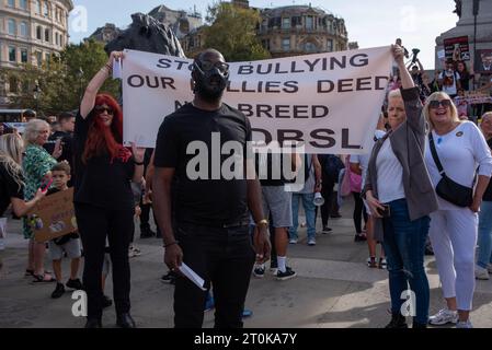 London, Großbritannien. Oktober 2023. Ein Demonstrant trägt eine menschliche Maulmaske, während andere während der Demonstration ein Banner hinter sich halten. Die britische Regierung kündigte am 15. September an, dass die "American XL Bully"-Hunde Ende 2023 im Vereinigten Königreich nach einer Reihe schrecklicher Angriffe verboten werden. Seitdem protestieren die Besitzer jedes Wochenende gegen die Entscheidung der Regierung und geben dem Premierminister Rishi Sunak persönlich die Schuld dafür. Quelle: SOPA Images Limited/Alamy Live News Stockfoto