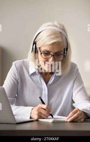Fokussierte, glückliche ältere Studentin, die sich das Trainingsseminar ansieht Stockfoto