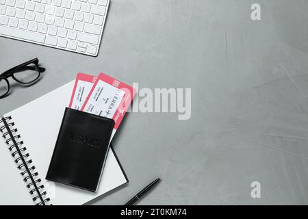 Flache Lay-Komposition mit Tickets, Reisepass und Notizbuch auf hellgrauem Tisch, Platz für Text. Geschäftsreise Stockfoto