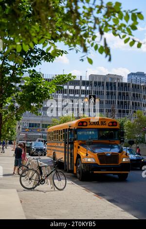 Ein gelber Bus fährt durch die moderne Stadt Calgary. Calgary, Kanada - 06.29.23 Stockfoto