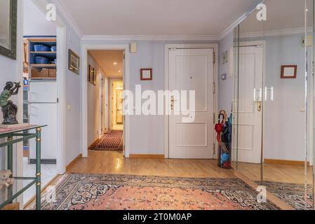 Quadratischer Saal eines Hauses mit gepanzerter weißer Holztür Stockfoto