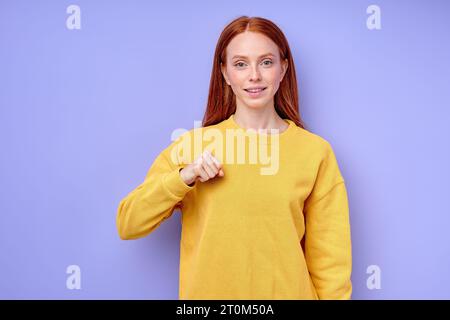 Junge taub stumme fröhliche Frau, die lernt, wie man Zeichensprache spricht, Nahaufnahme Porträt isoliert blauer Hintergrund Studio-Aufnahme Alphabet - Buchstabe A Rechtschreibung Stockfoto