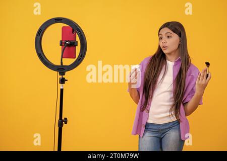 Ein schockiertes Teenager-Mädchen hat einen Kosmetikblog im Hintergrund. Foto von Teenager-Mädchen hat Kosmetik-Blog Stockfoto