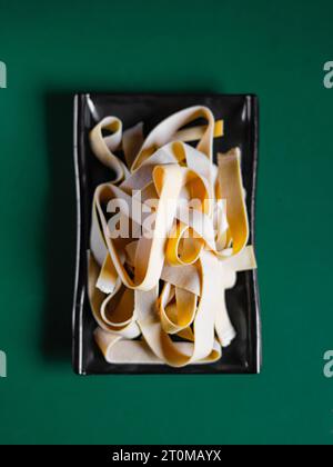 Tofu-Nudeln auf einem schwarzen Teller. Blick von oben. Chinesische Küche, Zutat für Hotpot Stockfoto