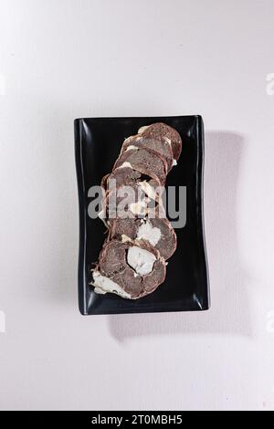 Pferdefleisch-Kazy auf einem schwarzen Teller. Blick von oben. Chinesische Küche, Zutat für Hotpot Stockfoto