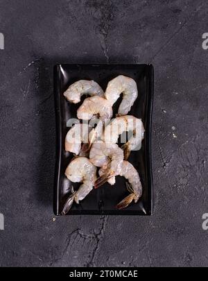 Riesige Seegarnelen auf einem schwarzen Teller. Blick von oben. Chinesische Küche, Zutat für Hotpot Stockfoto