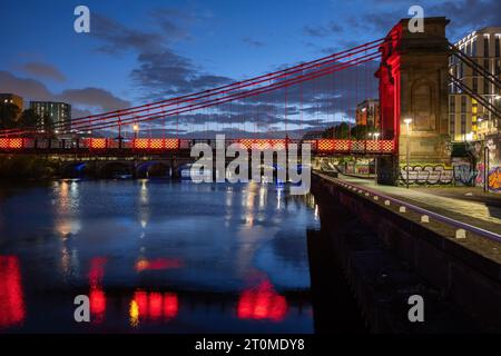 Die South Portland Street Suspension Bridge bei Nacht, Fußgängerbrücke über den Fluss Clyde in Glasgow, Schottland, Großbritannien. Stockfoto