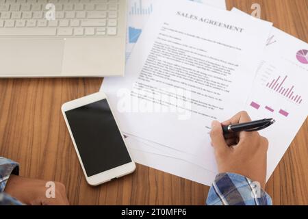 Nahaufnahme der freiberuflichen männlichen Hand, die offizielle Dokumente ausfüllt, Vertrag unterzeichnet und Steuern. Geschäftsdokument und Kaufvertrag Stockfoto