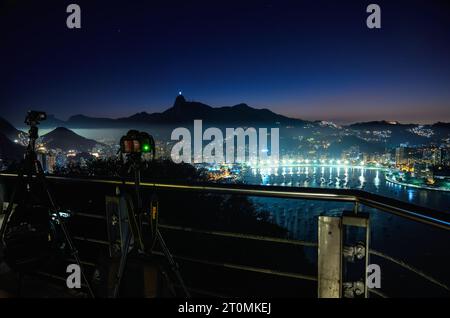 Kameras auf Stativen erfassen die Skyline von Rio de Janeiro vom Zuckerhut bei Nacht Stockfoto