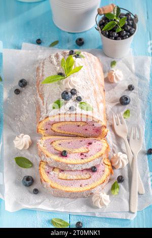 Leckere Blaubeeren-schweizer Roulette als Frühlingsdessert. Mango schweizer Brötchen mit Beeren und Zucker. Stockfoto