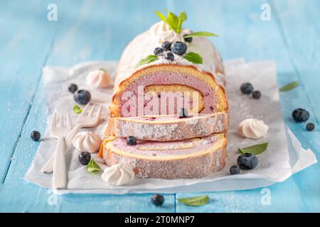 Hausgemachte Blaubeere schweizer Roulette als Frühlingsdessert. Mango schweizer Brötchen mit Beeren und Zucker. Stockfoto