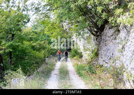 Mutter und Sohn, Touristen auf einer Radtour durch die Landschaft rund um Pivka, Radfahren auf der alten italienischen Militärstraße, die vor dem Ersten Weltkrieg gebaut wurde, slowenien Stockfoto