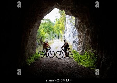 Mutter und Sohn, Touristen auf einer Radtour mit MTB in der Landschaft rund um Pivka, am Eingang des alten italienischen Militärtunnels, slowenien Stockfoto